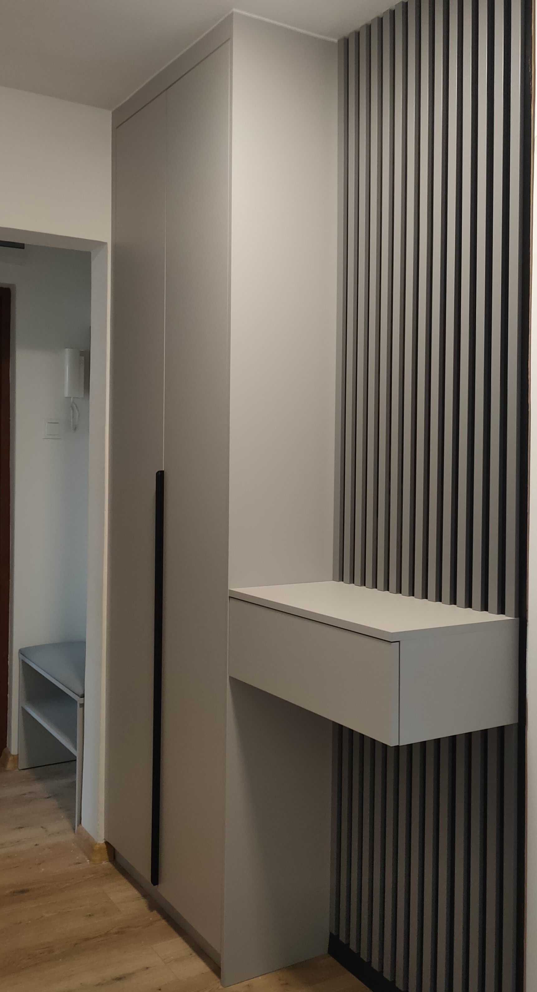 Minimalistyczna zabudowa przedpokoju z lamelami